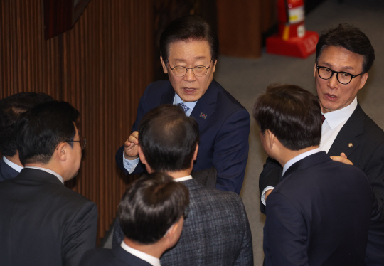 이재명(가운데) 더불어민주당 대표가 28일 국회 본회의에서 동료 의원들과 대화하고 있다.<연합뉴스 사진>